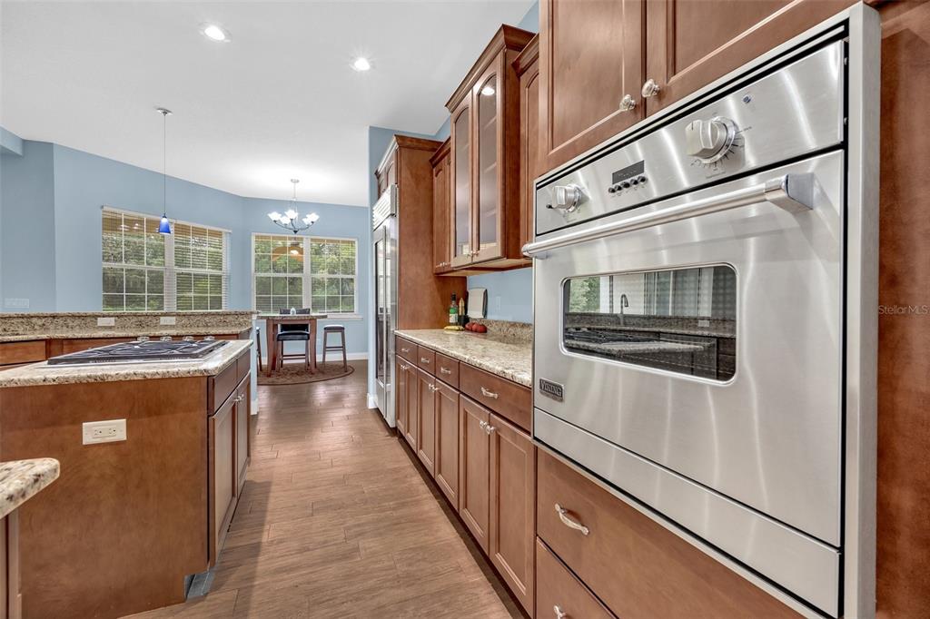 9824 Brantley Road Lithia, FL 33547 - Photo 12 of 38 a kitchen with stainless steel appliances granite countertop a refrigerator a stove and a wooden cabinets
