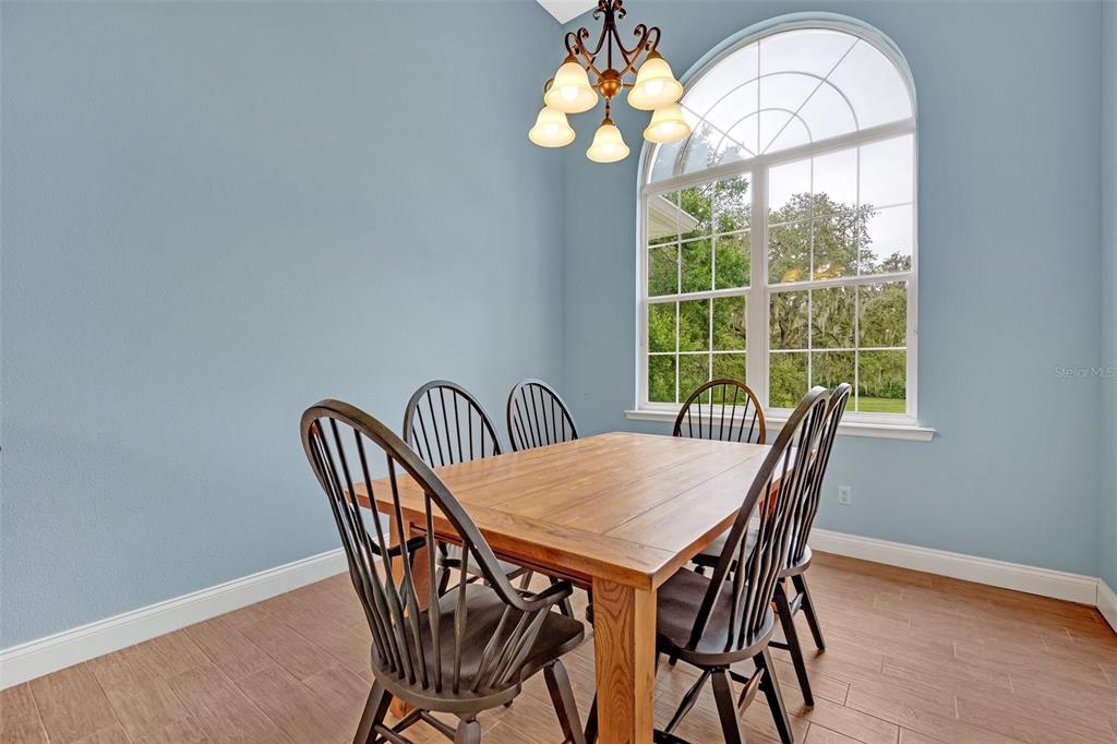 9824 Brantley Road Lithia, FL 33547 - Photo 4 of 38 a view of a dining room with furniture a chandelier and wooden floor