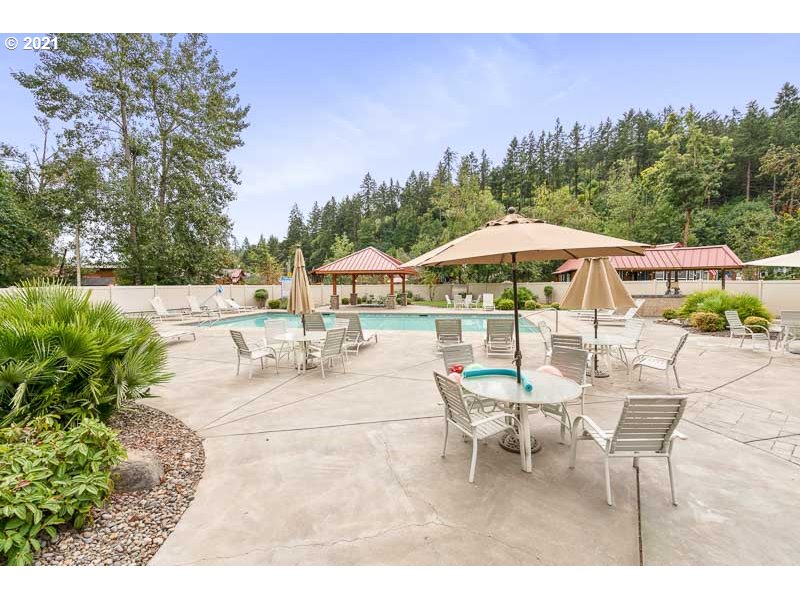 8372 Enchanted Way Southeast, Unit 192 Turner, OR 97392 - Photo 23 of 27 a patio with a table and chairs under an umbrella