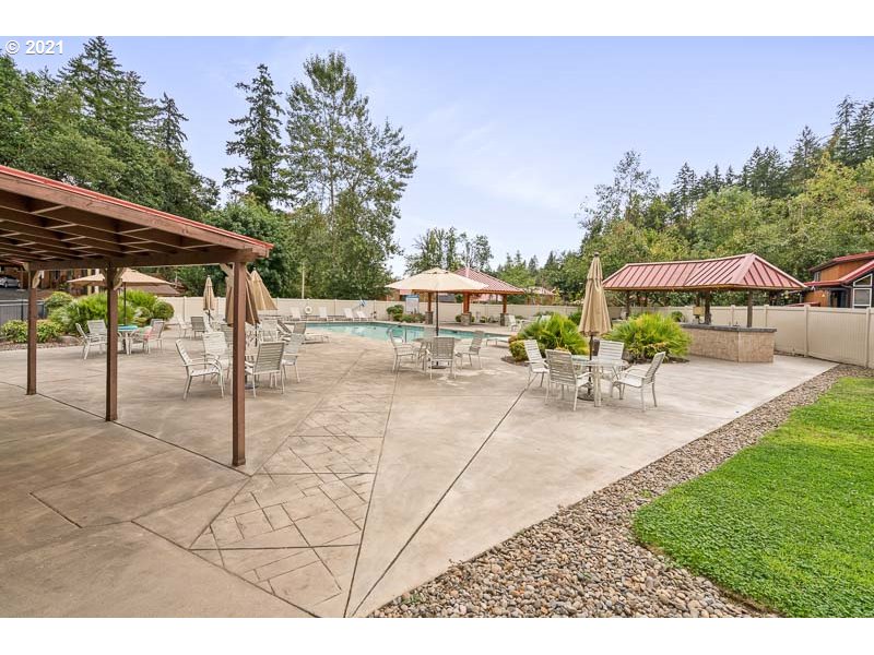 8372 Enchanted Way Southeast, Unit 192 Turner, OR 97392 - Photo 24 of 27 a view of a yard with table and chairs under an umbrella