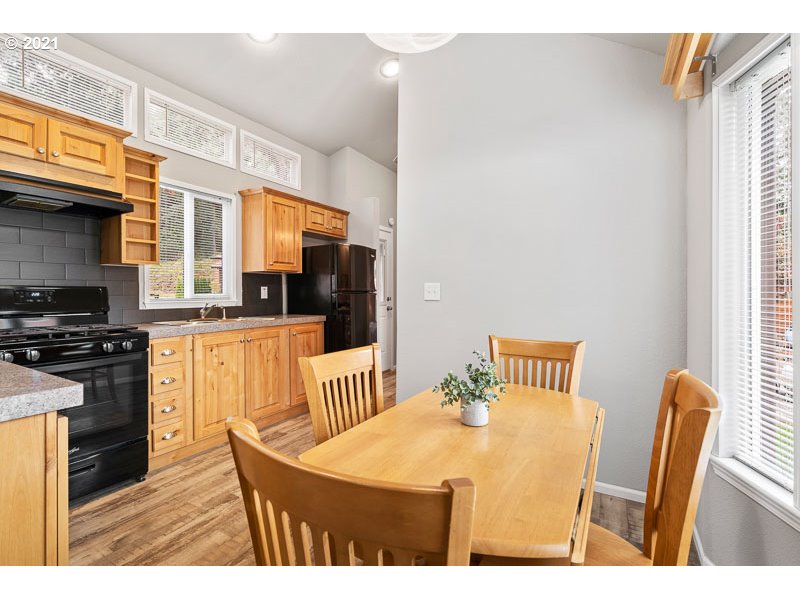 8372 Enchanted Way Southeast, Unit 192 Turner, OR 97392 - Photo 7 of 27 a kitchen with stainless steel appliances kitchen island granite countertop a table chairs and a refrigerator