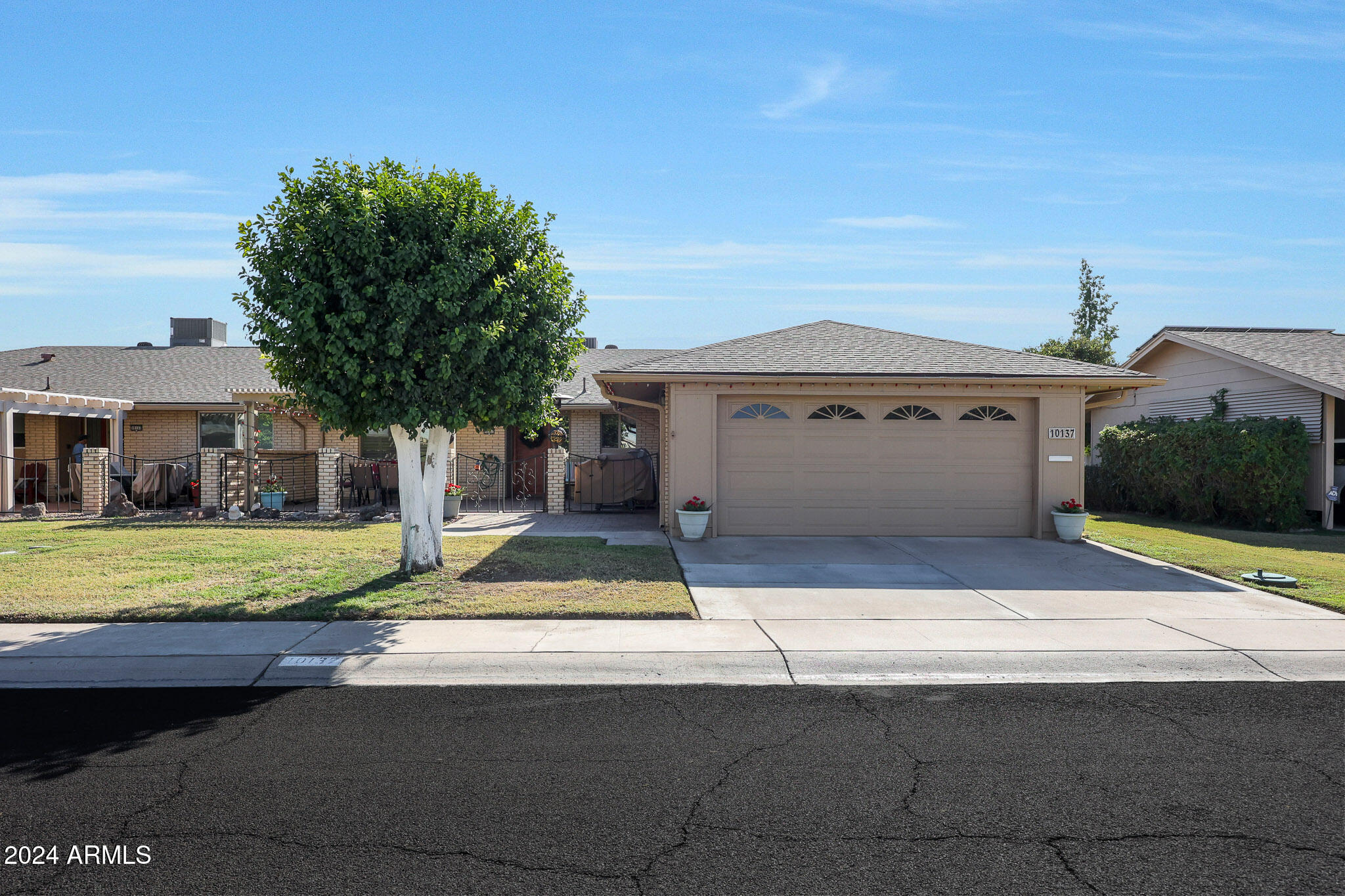 10137 West Mountain View Road Sun City, AZ 85351 - Photo 1 of 34 a front view of a house with a yard and garage