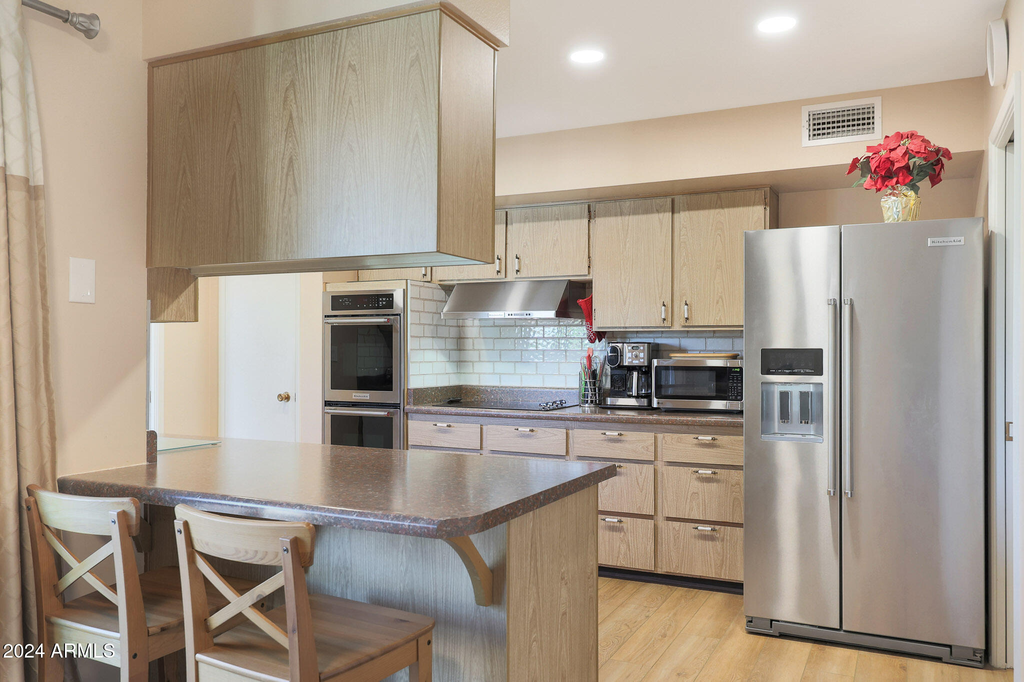 10137 West Mountain View Road Sun City, AZ 85351 - Photo 12 of 34 a kitchen with cabinets wooden floor and stainless steel appliances