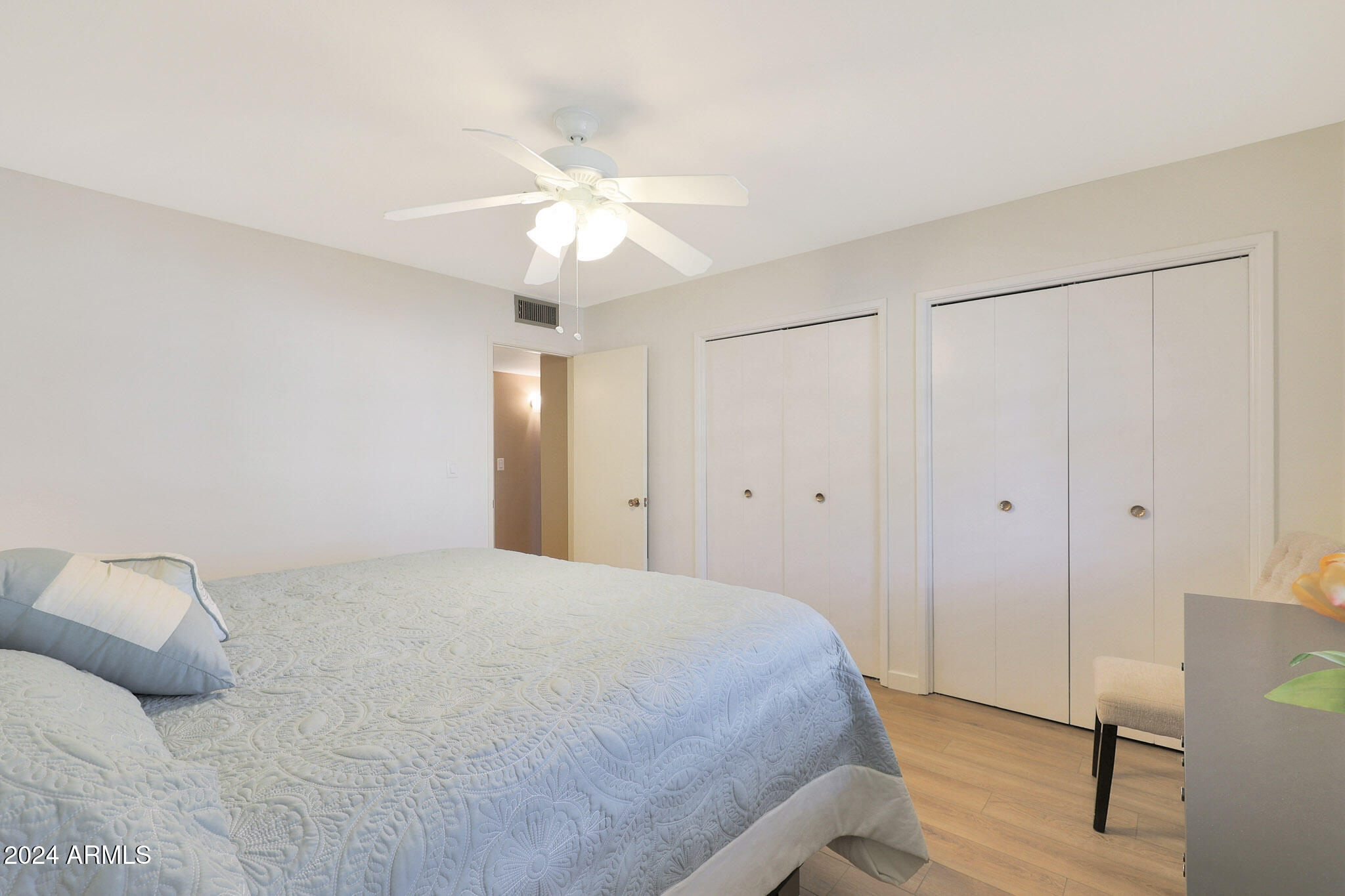 10137 West Mountain View Road Sun City, AZ 85351 - Photo 28 of 34 a bedroom with a bed and a chandelier