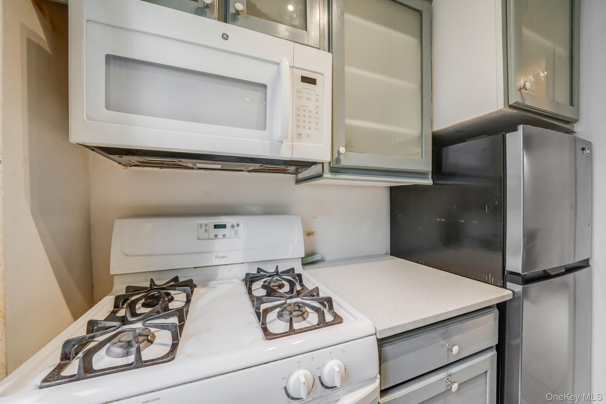 98-33 64th Avenue, Unit 1D Queens, NY 11374 - Photo 14 of 20 a kitchen with a refrigerator and a stove