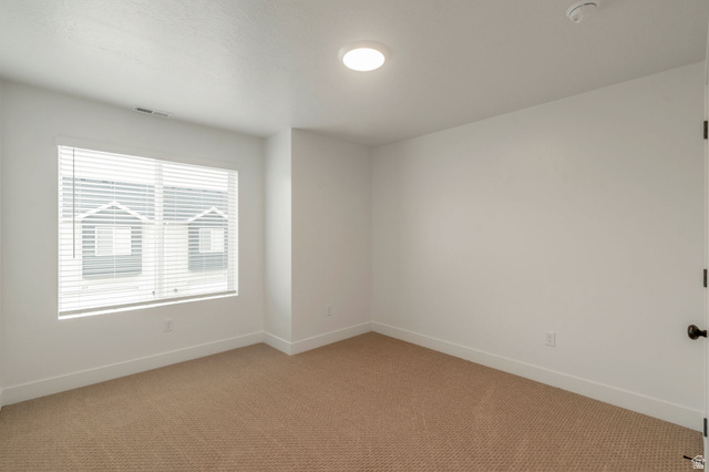 30 South Moonlit Road Mapleton, UT 84664 - Photo 17 of 25 Room featuring a large window with horizontal blinds, neutral-toned carpeting, white baseboards, and a ceiling-mounted light fixture