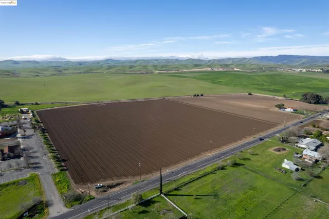 a view of a big yard with an ocean view