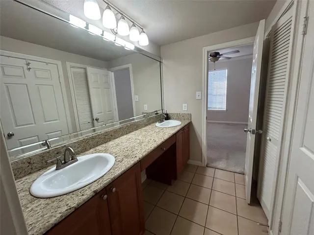 a bathroom with a granite countertop sink a mirror and a shower