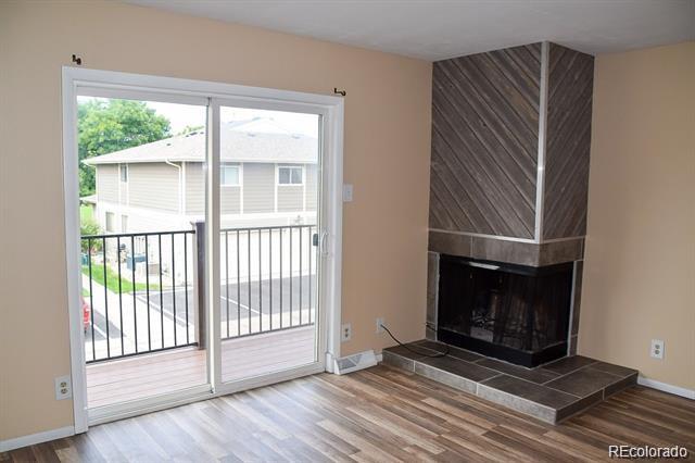 1225 South Oneida Street, Unit 252 Denver, CO 80224 - Photo 2 of 20 a view of an empty room with wooden floor fireplace and a window