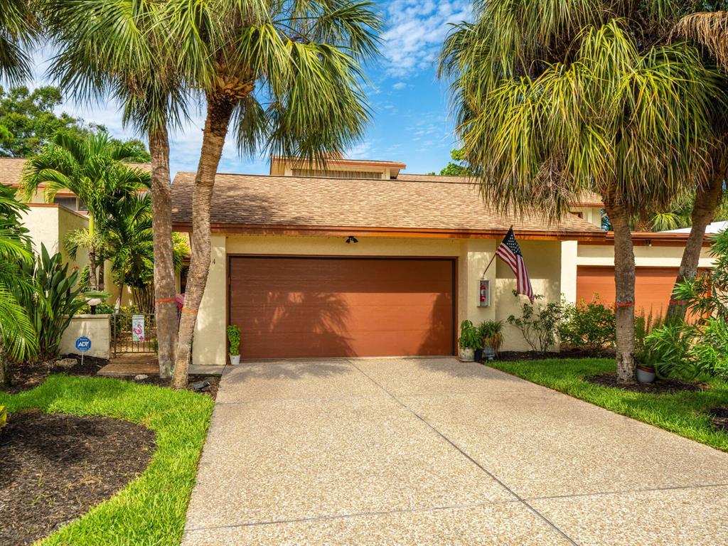 Landscaped, tropical front framed with palm trees!