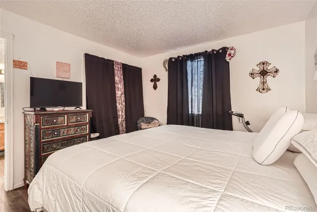 a large bedroom with bed and a furniture