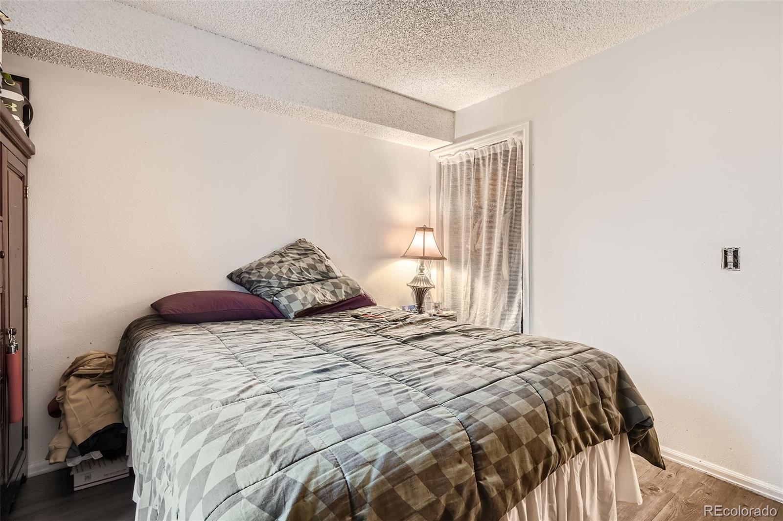 1358 South Irving Street, Unit 53 Denver, CO 80219 - Photo 23 of 28 a large bed sitting in a bedroom next to a window