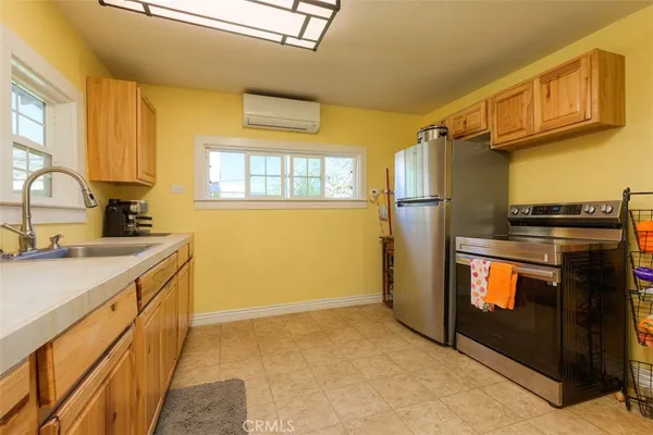 a kitchen with stainless steel appliances granite countertop a refrigerator a stove and a sink