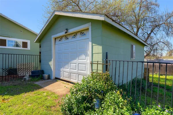 a backyard of a house with a garden and barbeque oven