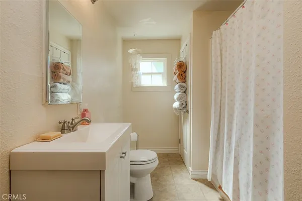 a bathroom with a sink a toilet and shower curtain