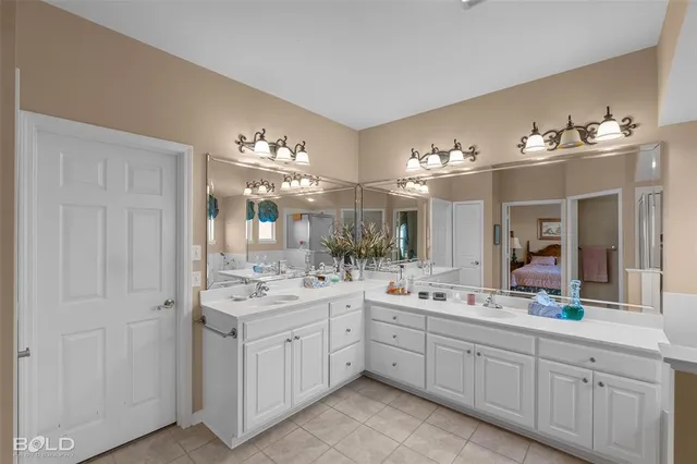 a large white kitchen with a sink and dishwasher with white cabinets