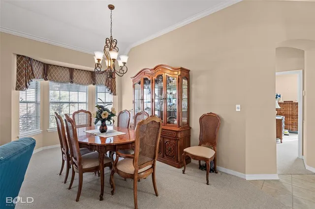 a dining room with furniture a chandelier and window