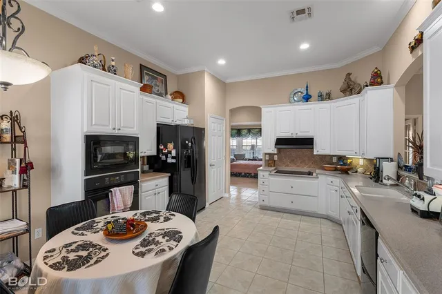 a kitchen with stainless steel appliances kitchen island granite countertop a sink dishwasher stove and refrigerator with wooden floor
