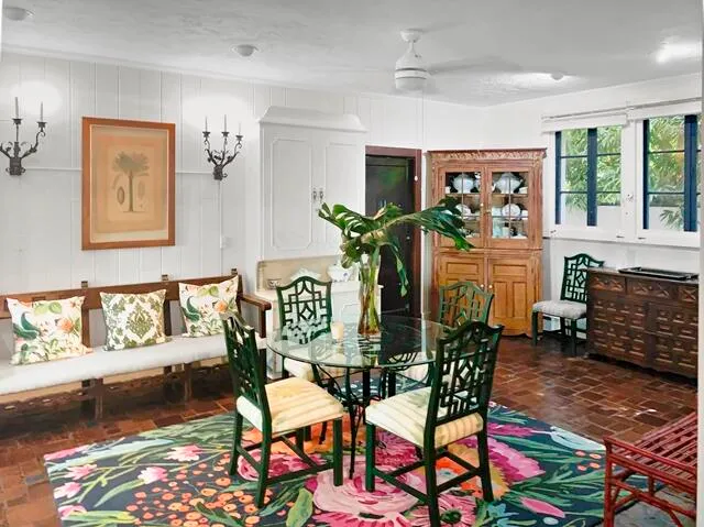 a view of a dining room with furniture one side kitchen view and wooden floor