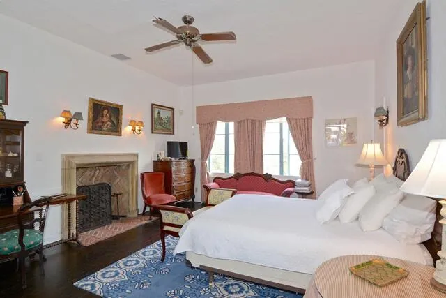 a bedroom with a bed a fireplace and window