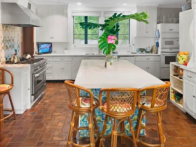 a kitchen with stainless steel appliances kitchen island granite countertop a table chairs sink and cabinets