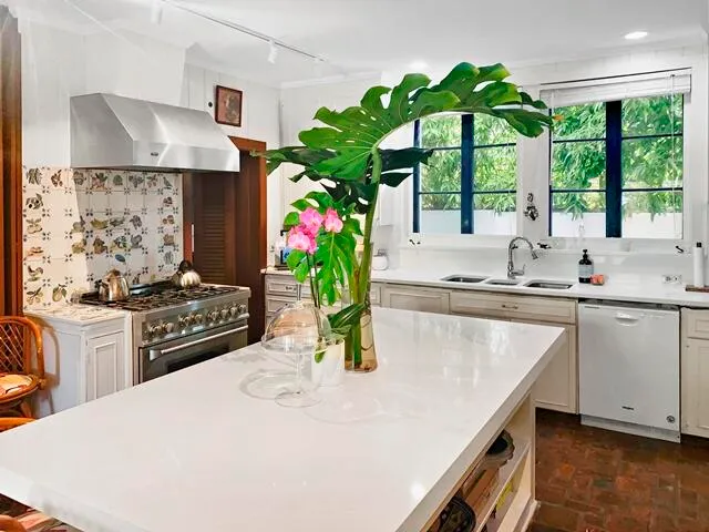 a kitchen with stainless steel appliances kitchen island granite countertop a stove a sink a counter space and cabinets