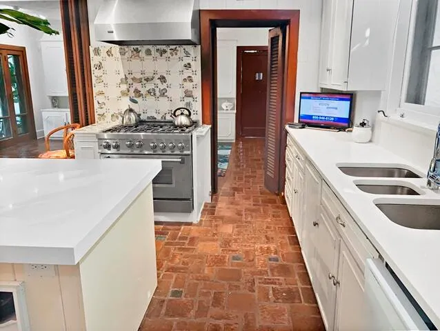 a kitchen with stainless steel appliances granite countertop a stove a sink and a refrigerator