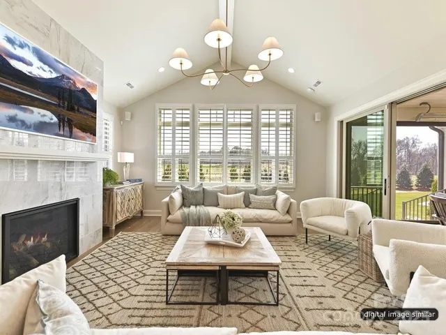 a living room with furniture chandelier and a fireplace