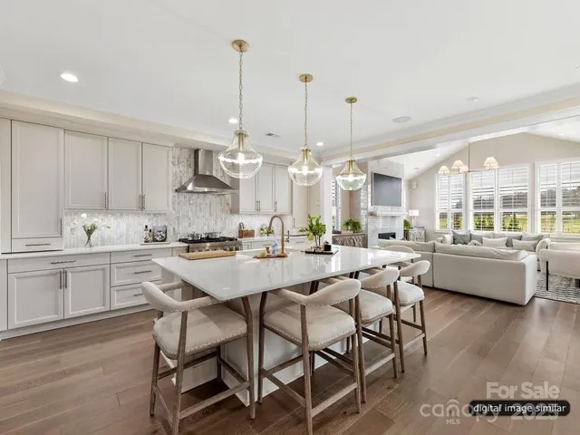 a kitchen with stainless steel appliances kitchen island granite countertop a stove a sink a dining table and chairs with wooden floor