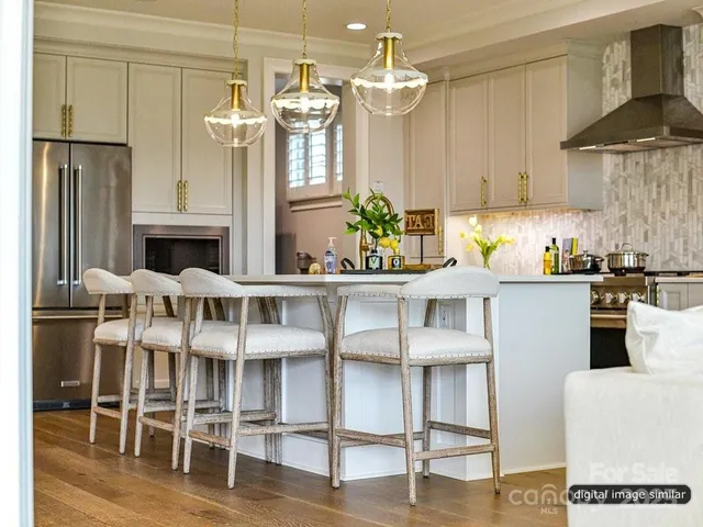 a kitchen with stainless steel appliances kitchen island granite countertop a table and chairs