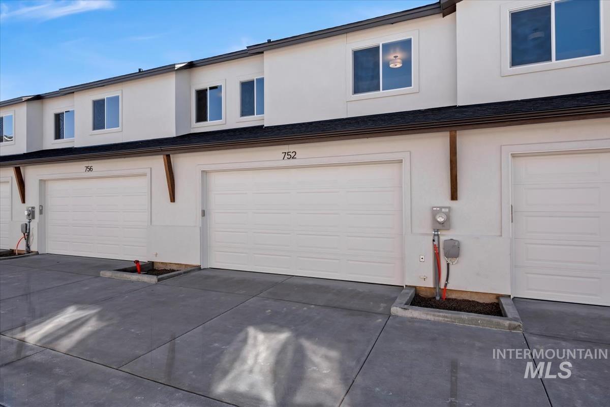 752 South Calhoun Lane Star, ID 83669 - Photo 35 of 45 Modern townhome exterior with white stucco finish and individual garage access