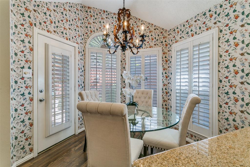 14596 Blueberry Court Addison, TX 75001 - Photo 17 of 32 Dining room featuring hanging lights, wallpapered walls, wood finished floors, and vaulted ceiling