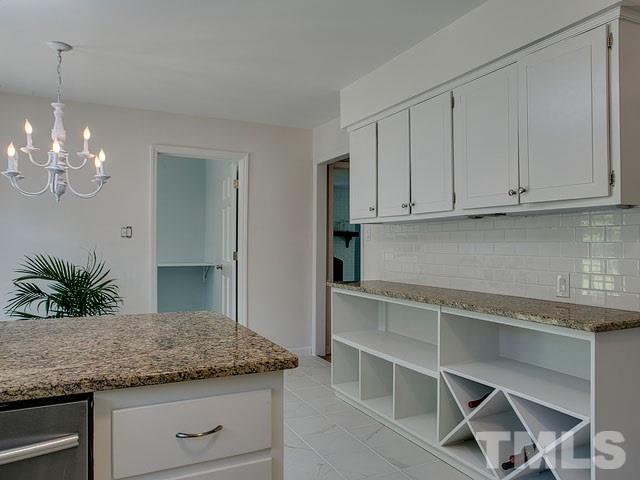 1937 Fountain Ridge Road Chapel Hill, NC 27517 - Photo 11 of 24 a kitchen with kitchen island granite countertop cabinets and window