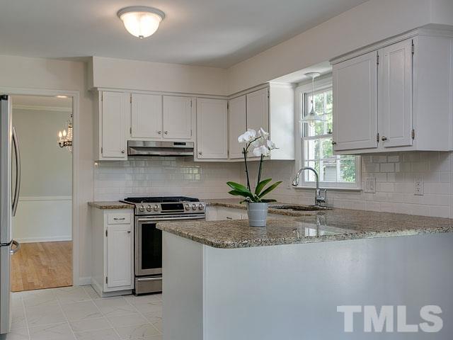 1937 Fountain Ridge Road Chapel Hill, NC 27517 - Photo 12 of 24 a kitchen with stainless steel appliances granite countertop a stove a sink and a white cabinets