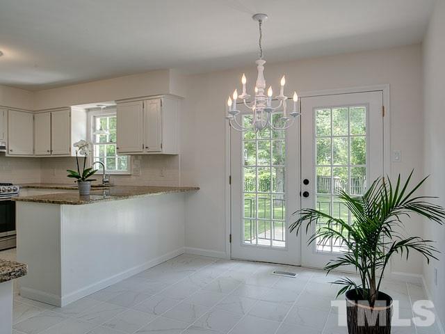 1937 Fountain Ridge Road Chapel Hill, NC 27517 - Photo 13 of 24 a kitchen with windows and potted plant