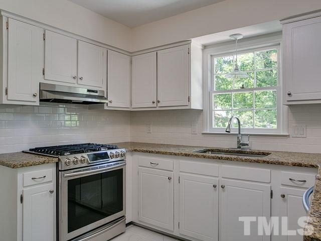 1937 Fountain Ridge Road Chapel Hill, NC 27517 - Photo 10 of 24 a kitchen with granite countertop stainless steel appliances white cabinets granite counter tops and a wooden floors