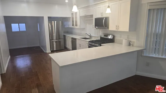 a kitchen with stainless steel appliances a refrigerator sink and microwave