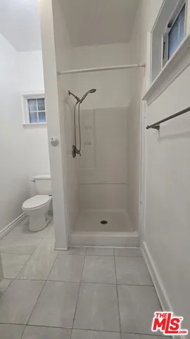 a bathroom with a shower a toilet and sink