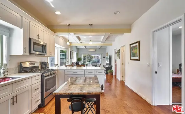 a kitchen with stainless steel appliances granite countertop a stove refrigerator and cabinets