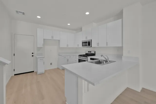 a kitchen with a sink a stove and cabinets