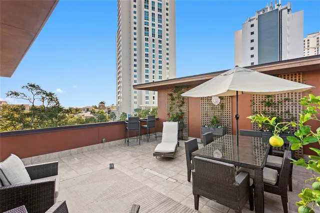 an aerial view of a city with lots of residential buildings ocean and mountain view in back