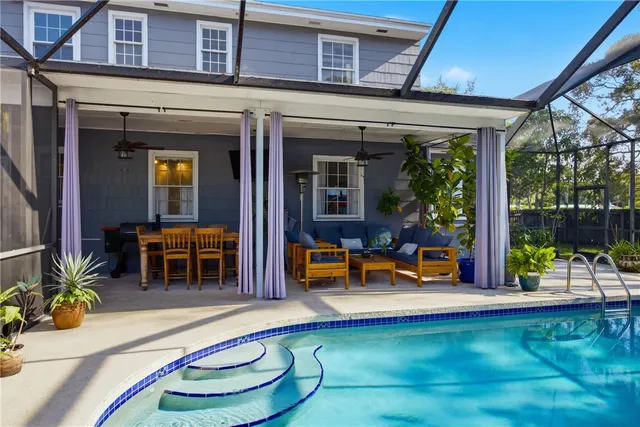 a view of a house with swimming pool and sitting area