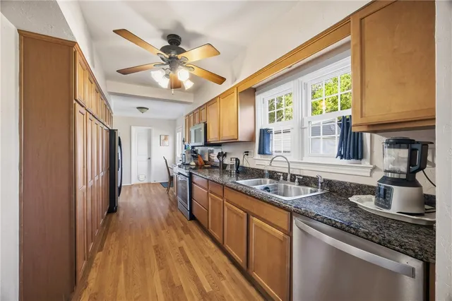 a kitchen with stainless steel appliances granite countertop lots of counter top space and wooden floor