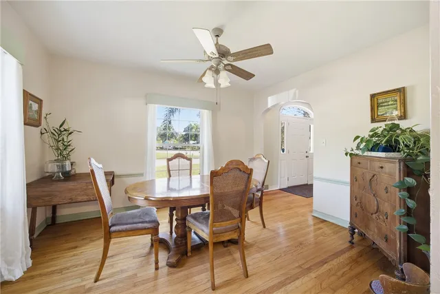 a dining room with furniture a potted plant and wooden floor