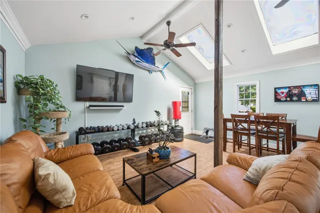 a living room with furniture a flat screen tv and a window