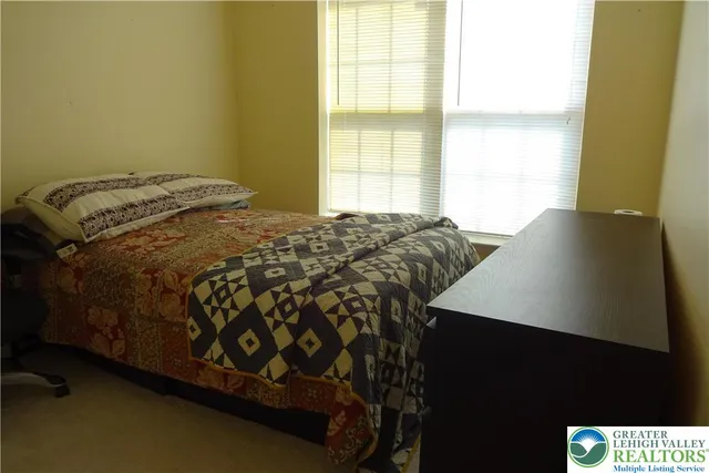 a bed sitting in a bedroom next to a window