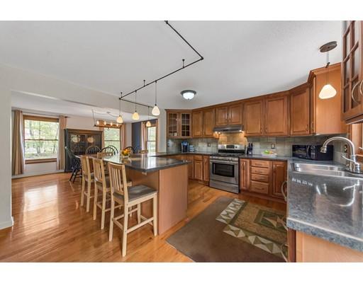 125 Thayer Road Monson, MA 01057 - Photo 8 of 30 a kitchen with stainless steel appliances granite countertop a stove top oven a sink a dining table and chairs with wooden floor