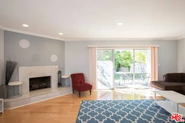 a living room with furniture a fireplace and a large window
