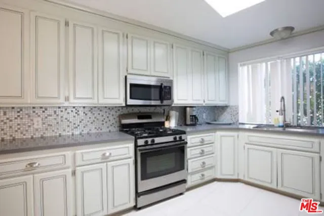 a kitchen with white cabinets and white appliances