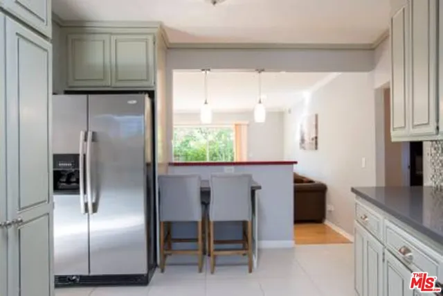 a kitchen with kitchen island a counter top space cabinets and a refrigerator